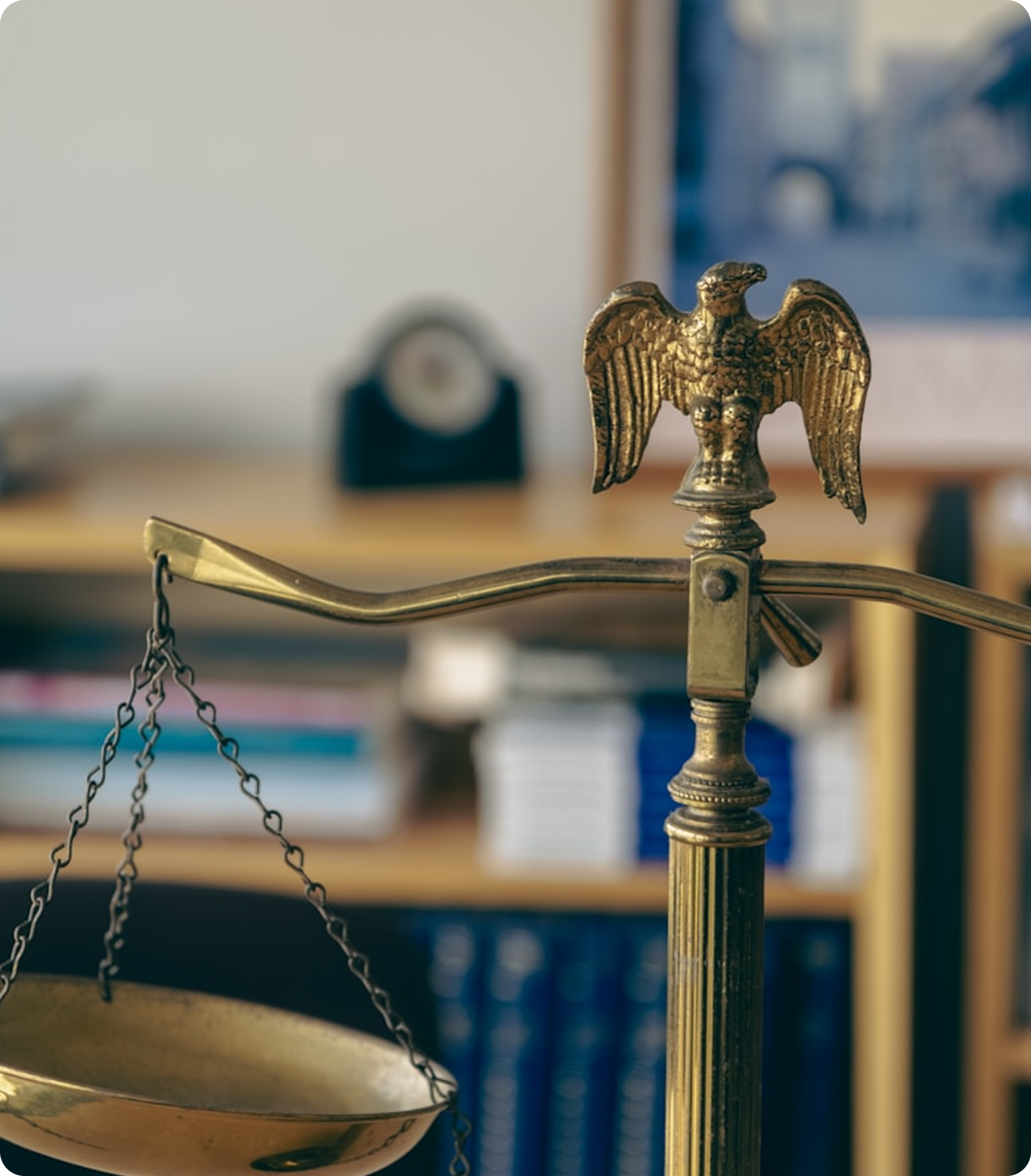 Brass scale of justice with law books in the background